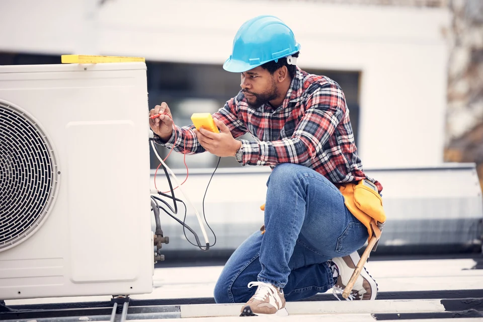Air-conditioning electrical testing and AC circuit services in Gauteng Electrician testing the electrical supply at an outdoor air-conditioning unit in Gauteng