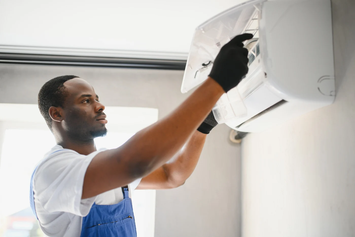 Air-conditioning electrical fault finding and wiring repairs in Gauteng Technician inspecting an indoor air-conditioning unit during electrical fault finding
