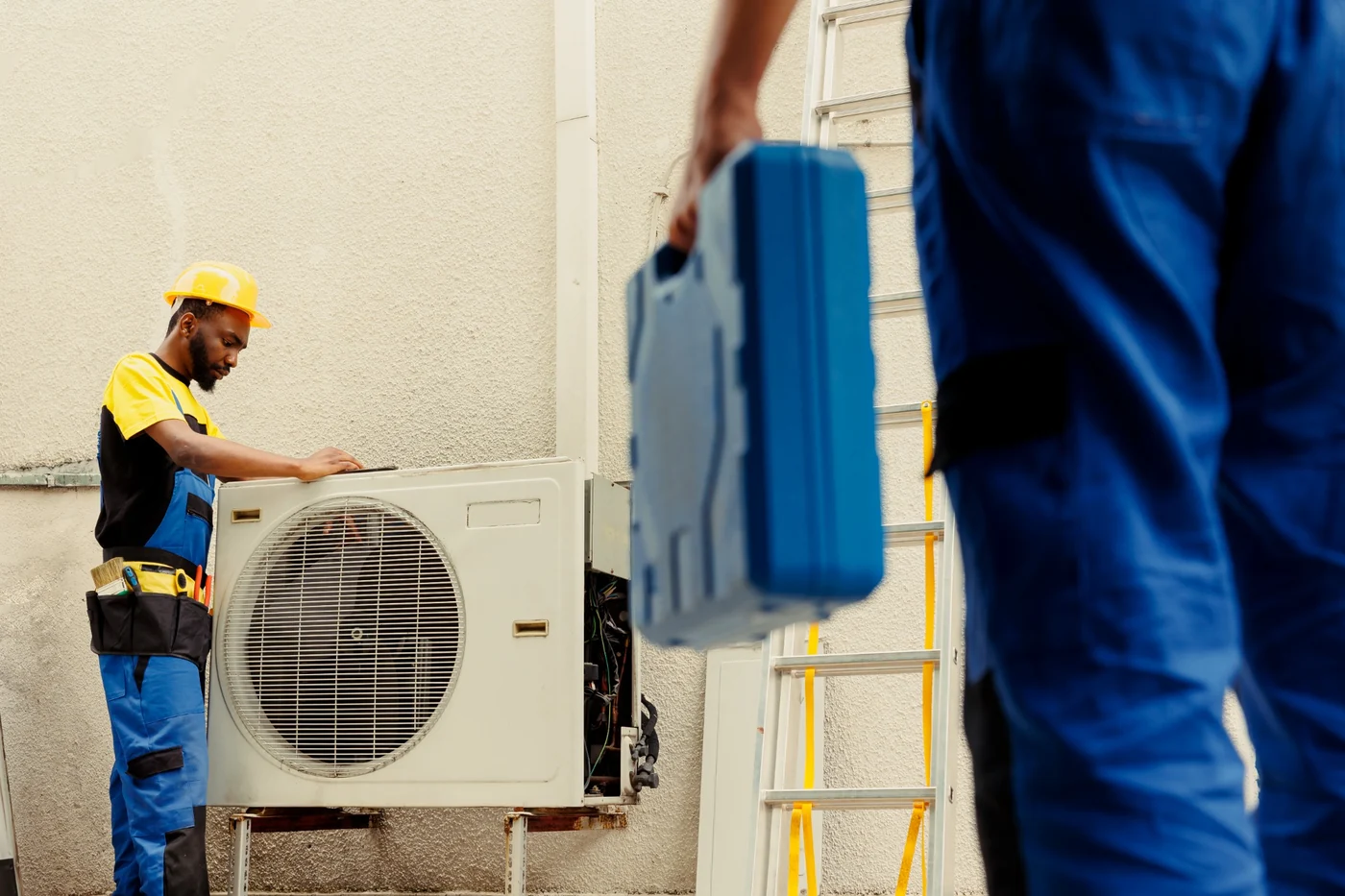 Air-conditioning electrical planning for solar inverter and generator backup power Technicians working on an outdoor air-conditioning unit during electrical planning and maintenance