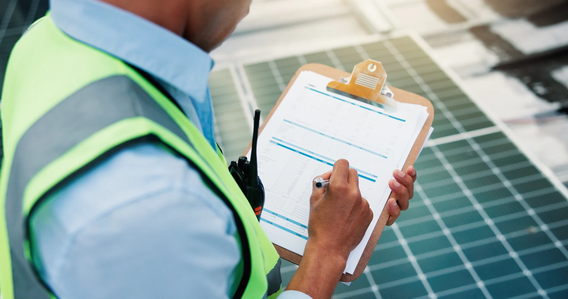 Electrical inspection checklist and documentation being completed beside solar panels