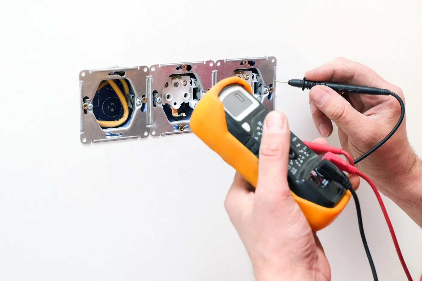 Plug point and socket electrical maintenance testing in Gauteng Electrician testing socket wiring with a multimeter during electrical maintenance