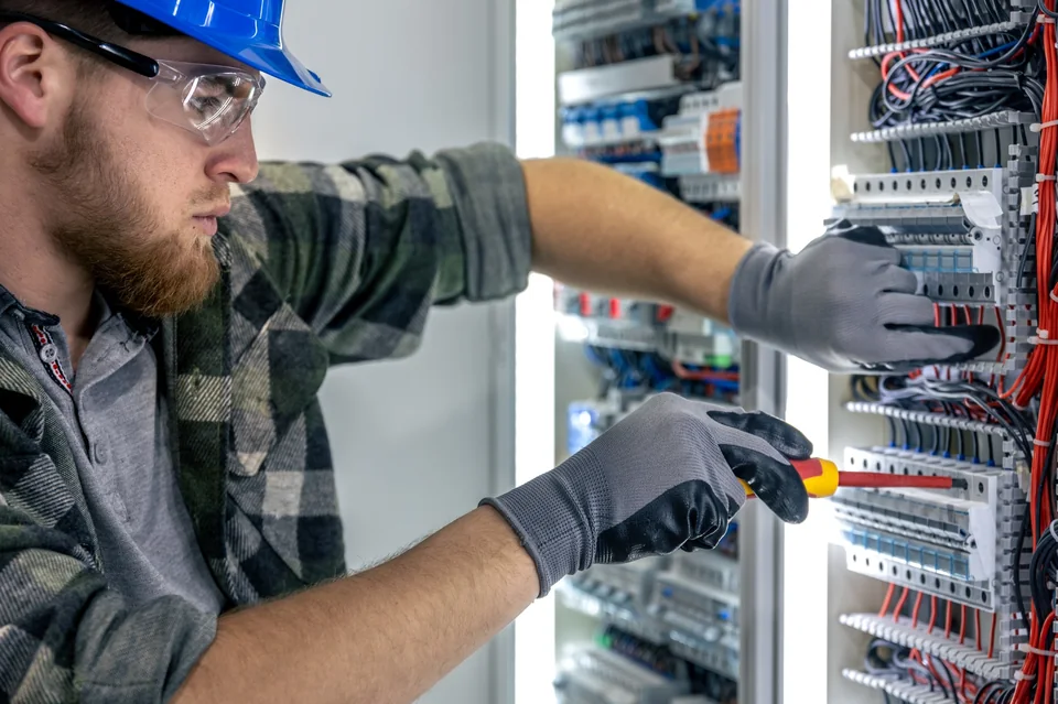 Electrician completing wiring inside an electrical panel