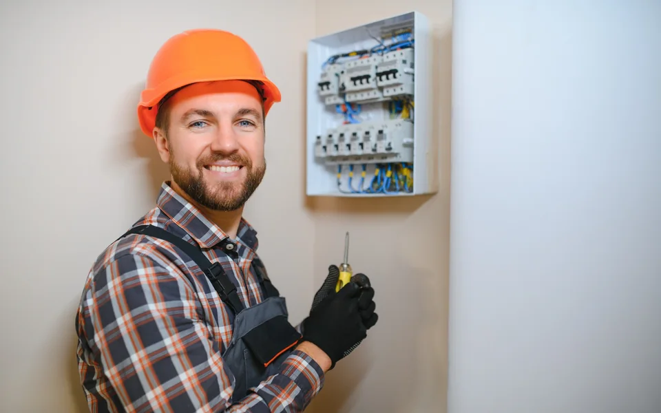 Residential electrician standing beside a home distribution board in Gauteng