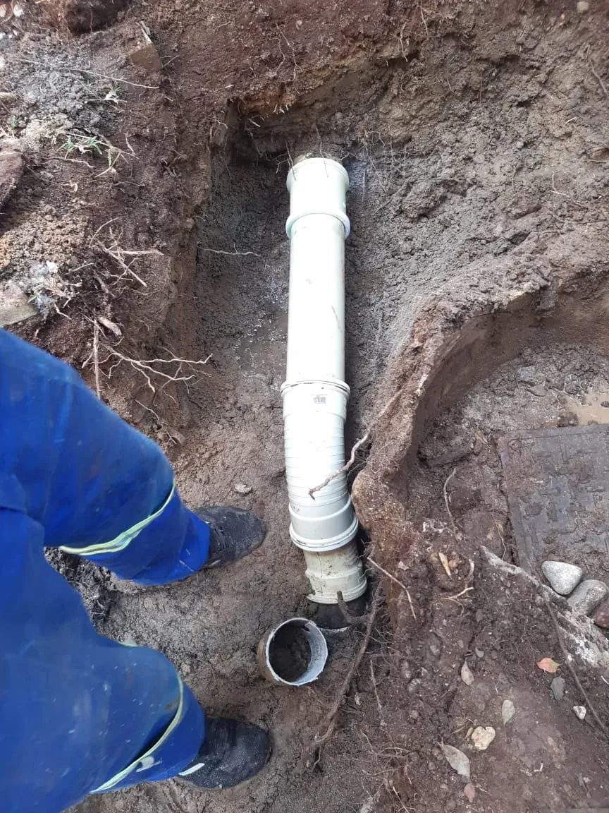 Excavated underground drain exposed for targeted pipe repair